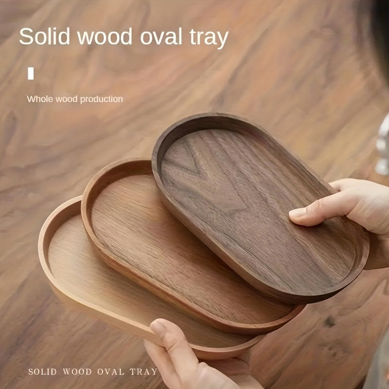Wooden oval trays with a hand holding one, on a wooden surface. - Lioré®