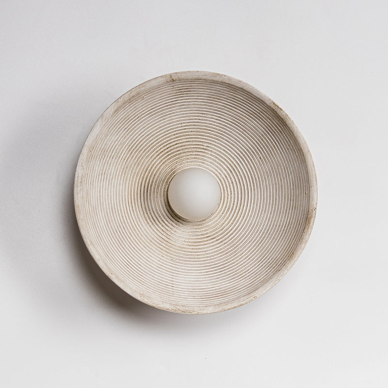 Round ceramic light holder with textured surface on a light gray background - Lioré® USA