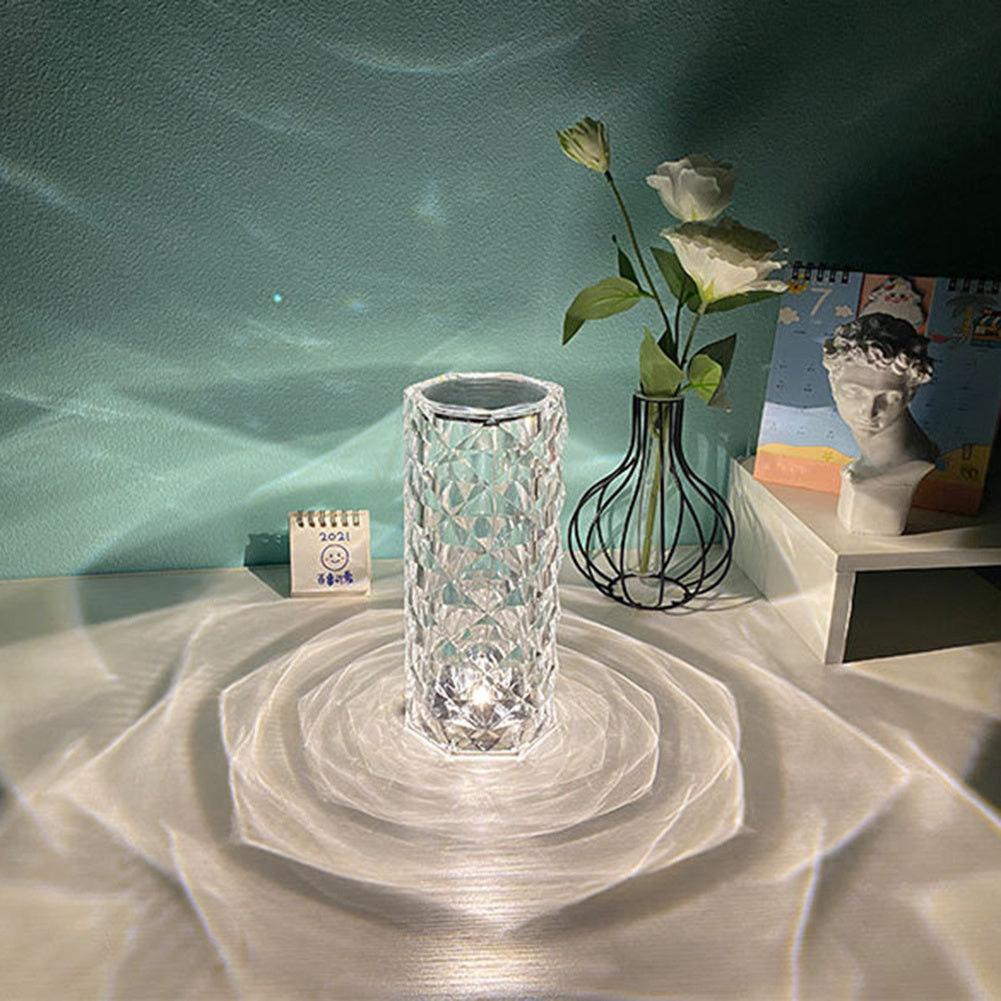 Crystal LED lamp on a textured surface with a calendar and decorative items in the background. - Lioré® USA