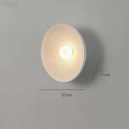 Round wall light fixture on a gray background with measurements indicated. - Lioré® USA