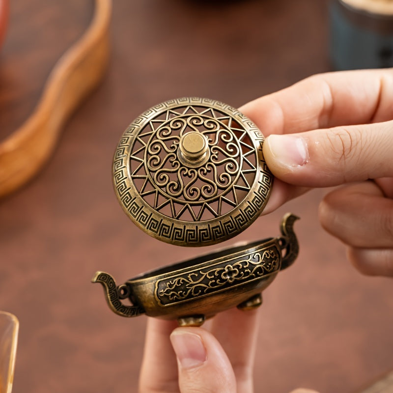 Person holding a decorative bronze object with intricate designs - Lioré®