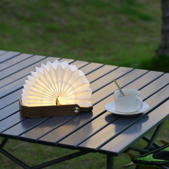 Wooden book-shaped lamp with a warm glow on a marble surface - Lioré® USA