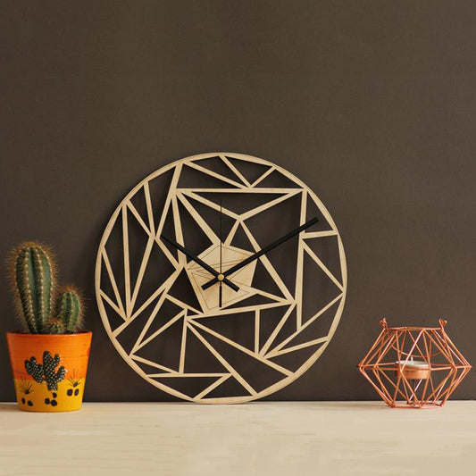 Geometric wall clock on a dark wall with a cactus and candle holder. - Lioré