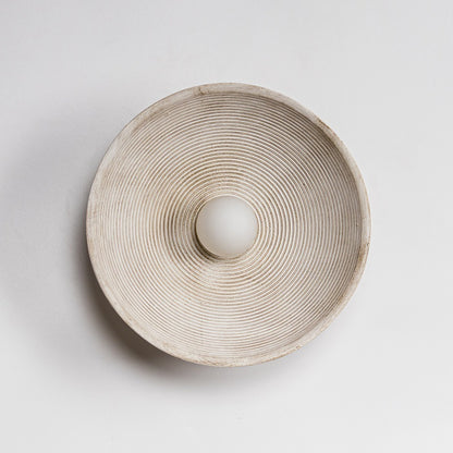 Round ceramic light holder with textured surface on a light gray background - Lioré® USA