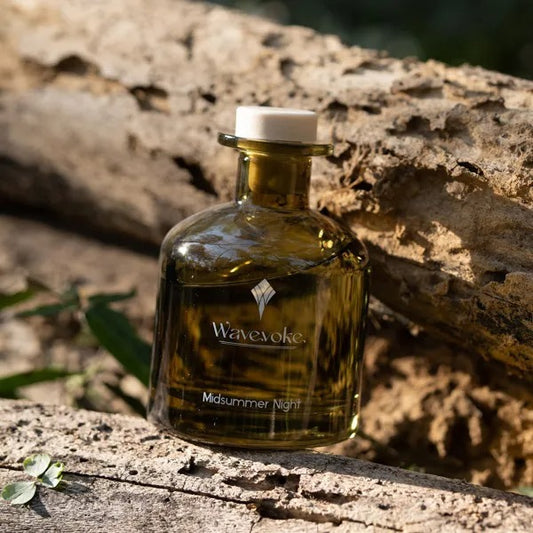 Bottle of 'Wavevoke Midsummer Night' on a wooden surface with natural background - Lioré®