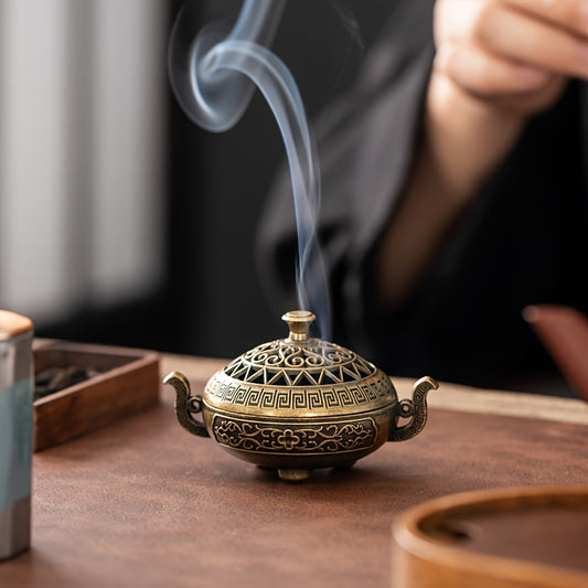 Bronze incense burner with smoke on a wooden table - Lioré®